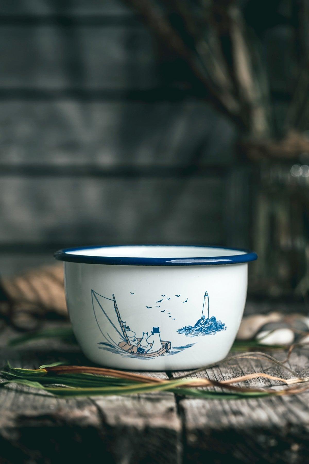 a blue and white bowl sitting on top of a wooden table